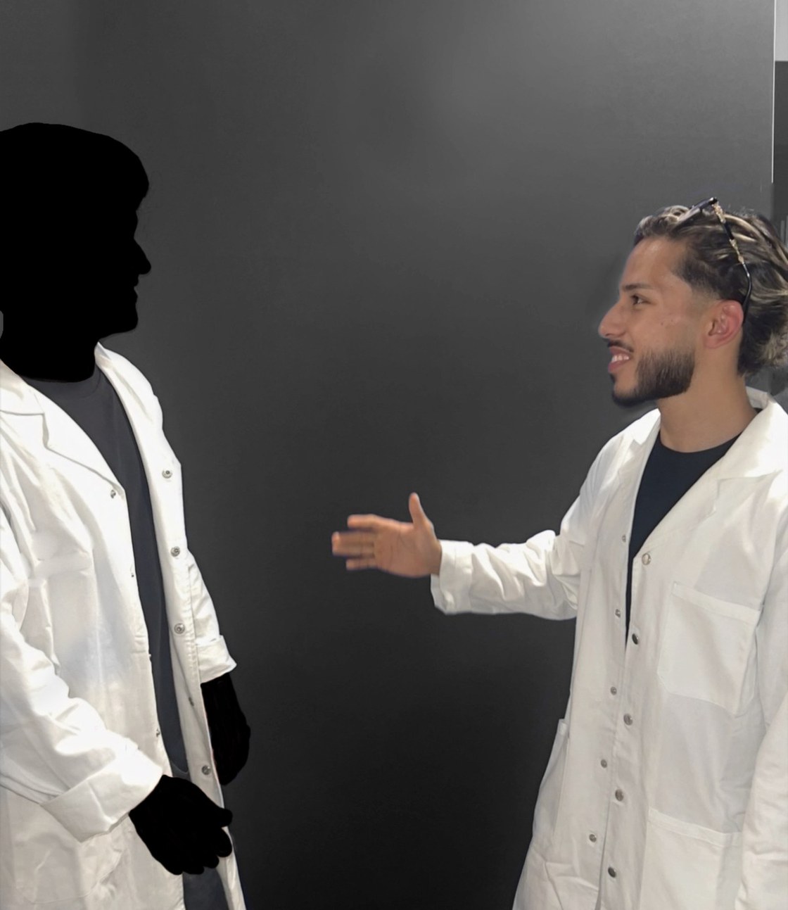 Josef im weissen Kittel reicht einer zweiten Person die Hand. Die zweite Person ist als schwarze Silhouette dargestellt.